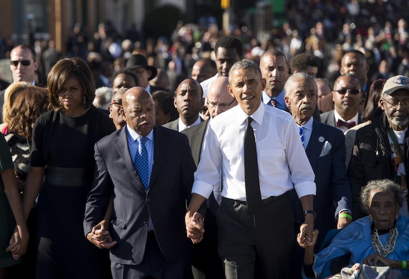 US President Barack Obama walks alongside Amelia Boynton Robinson, right, one of the original marchers, the Reverend Al Sharpton second right, First Lady Michelle Obama, left, and US Representative John Lewis, second left, Democrat of Georgia, and also one of the original marchers, across the Edmund Pettus Bridge to mark the 50th Anniversary of the Selma to Montgomery civil rights marches in Selma, Alabama. AFP