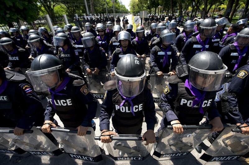 Thai riot policemen stand guard during an anti-government protest rally at the Air Force auditorium in Bangkok. Thailand's Election Commission called for the postponement of key parliamentary polls due to be held on July 20 because of political unrest shaking the kingdom. Pornchai Kittiwongsakul / AFP Photo