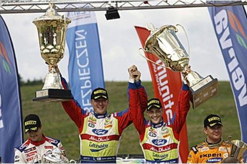 Mikko Hirvonen, centre right, celebrates taking the Rally of Poland with his co-driver Jarmo Lehtinen. The win puts the Finn first in the overall championship standings.