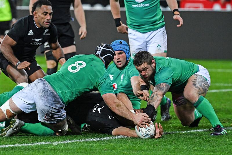 Ardie Savea of New Zealand scores a try as Caelan Doris, left, and Andrew Porter, right, of Ireland attempt a tackle. AP