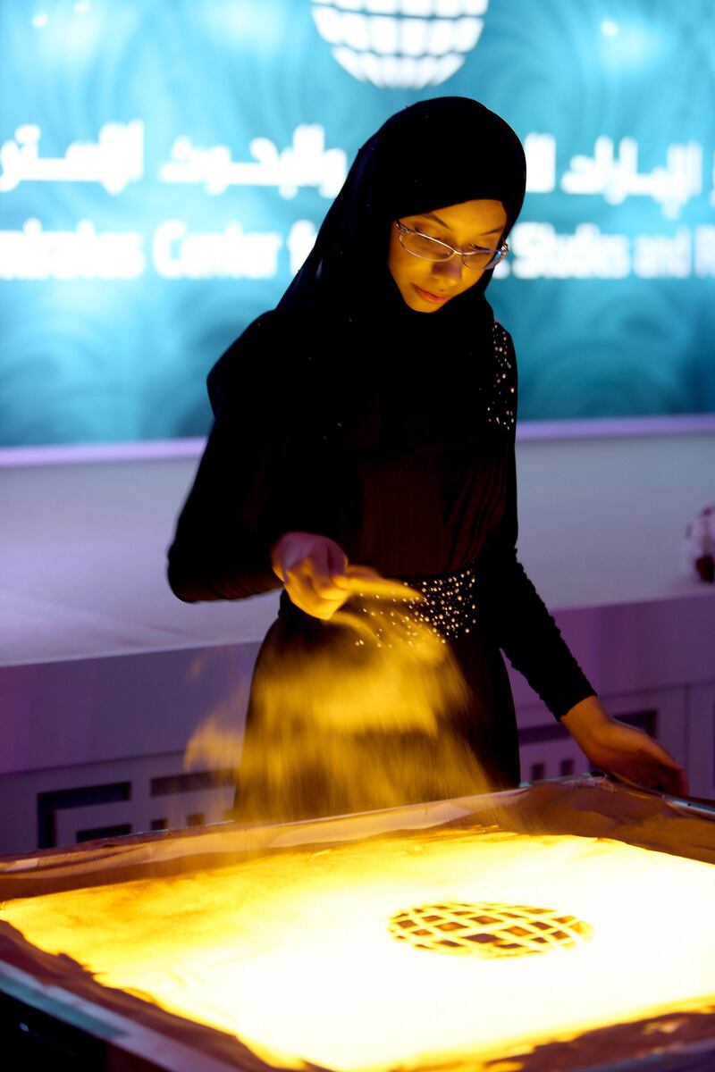 ABU DHABI , UNITED ARAB EMIRATES : July 30 , 2013 :- Shayma Al Maghairy from Oman during her sand art performance at the Ramadan tent in the  Emirates Centre for Strategic Studies and Research office in Abu Dhabi.  ( Pawan Singh / The National ) . For Arts & Life. Story by Anna Seaman
