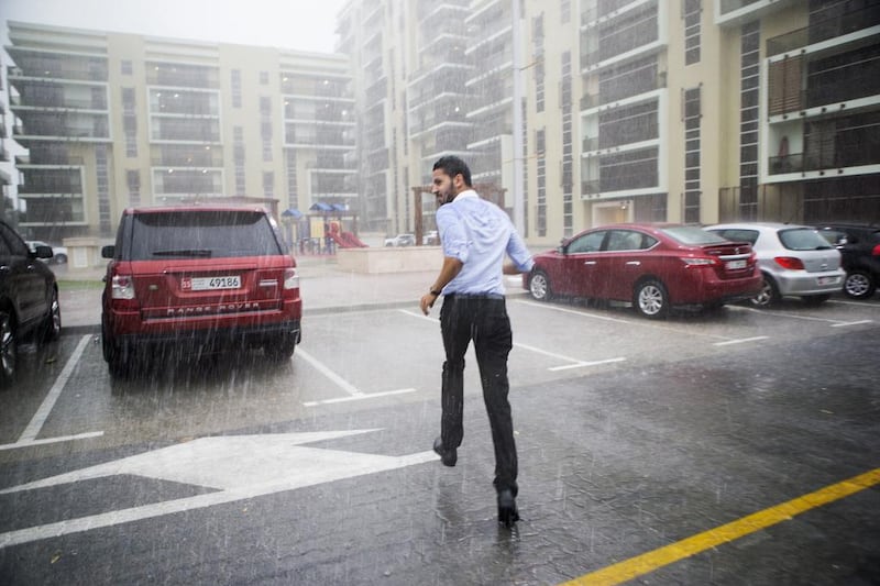 People run for cover during the March 9, 2016 storm in Khalifa City, Abu Dhabi, when strong winds and driving rain caused chaos across the UAE. Christopher Pike / The National