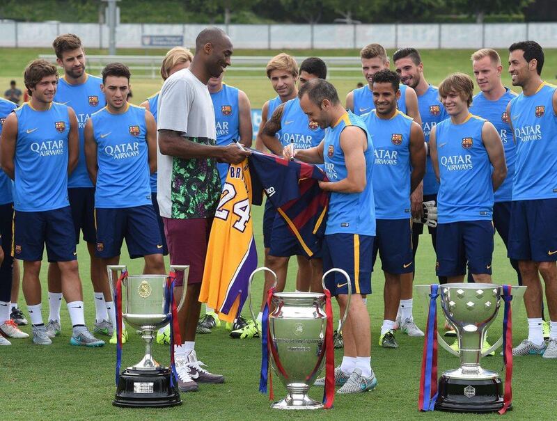 Los Angeles Lakers basketball star Kobe Bryant swaps shirts with Barcelona's Andres Iniesta, Bryant giving Iniesta one of his own and Andres Iniesta giving Bryant a custom Barca shirt, on Monday with the La Liga club in Southern California as part of their US tour. Mark Ralston / AFP