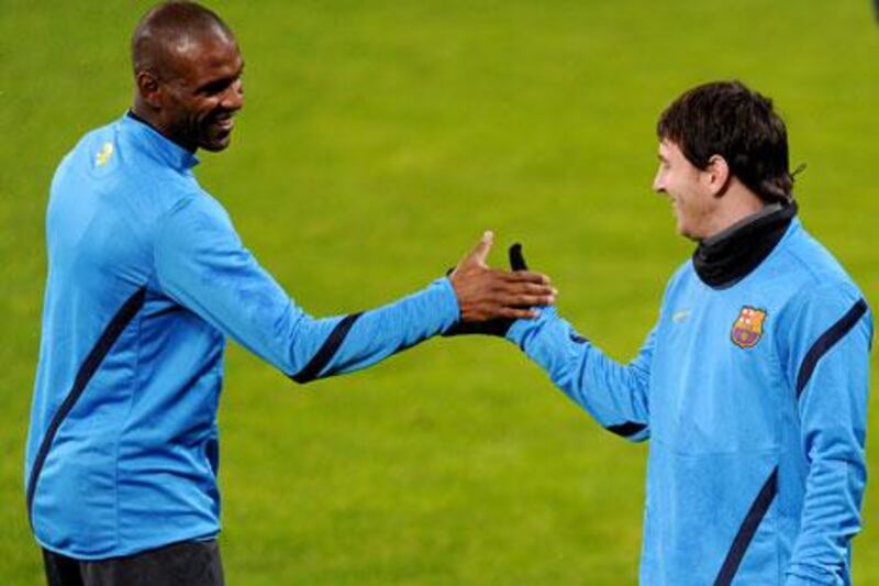 Eric Abidal and Lionel Messi exchange greetings during a warm-up with Barcelona before the player's liver transplant.
