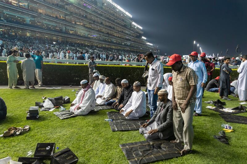 Spectators pray at the Meydan Racecourse in Dubai. The Dubai World Cup is taking place during Ramadan. Antonie Robertson / The National