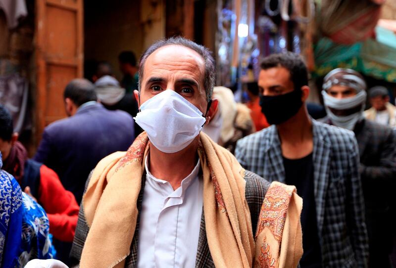 A man walks while clad in mask due to the COVID-19 coronavirus pandemic along an alley at an open-air market in Yemen's capital Sanaa on May 20, 2020, as Muslims shop ahead of the Eid al-Fitr holiday marking the end of the holy fasting month of Ramadan.  / AFP / Mohammed HUWAIS
