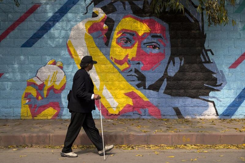 A blind man walks past graffiti of an Indian cricketer, on the wall of a stadium where the ICC World Twenty20 tournament will be held, in New Delhi.  Tsering Topgyal / AP Photo