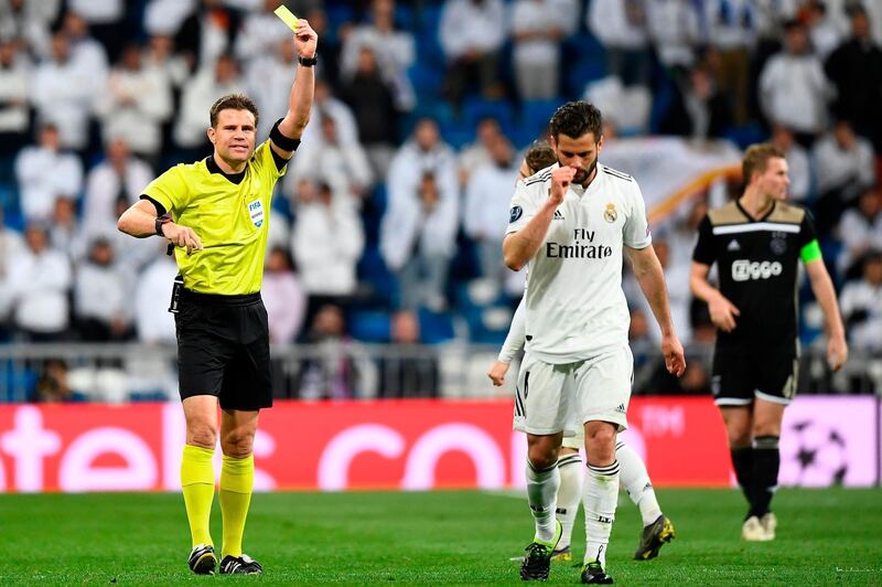 German referee Felix Brych shows a second yellow card to Real Madrid's Spanish defender Nacho Fernandez. AFP