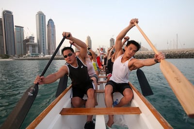 DUBAI, UNITED ARAB EMIRATES - August 18:  Members of a dragon boating club off shore from the Mina Seyahi hotel in the Dubai Marina, on August 18, 2008. The members meet three times a week to practice their rowing skills. In this photo Michael Wong (left) and Phil Co (right) lead the way.  (Randi Sokoloff / The National) *** Local Caption ***  RS019-DRAGONBOAT.jpgRS019-DRAGONBOAT.jpg