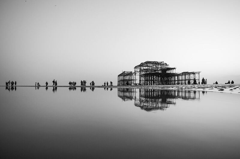 People enjoy the warm spring weather and low tide on Brighton beach on the southern coast of England. Getty