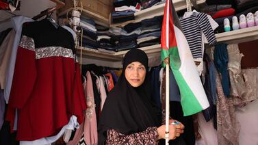 A shop owner carries a Palestinian flag in her store in the Shatila refugee camp in Beirut. AFP