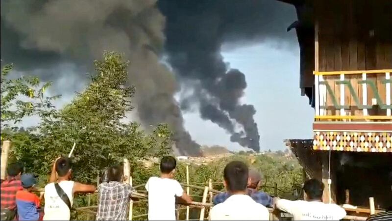 People look at thick columns of black smoke from Hkamti, Sagaing, Myanmar May 22, 2021 in this picture obtained from social media. News Anassador via REUTERS   ATTENTION EDITORS - THIS IMAGE HAS BEEN SUPPLIED BY A THIRD PARTY. MANDATORY CREDIT. MUST CREDIT NEWS AMBASSADOR.  NO RESALES. NO ARCHIVES.