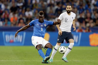 FILE -  In this Friday, June 1, 2018 file photo, Italy's Mario Balotelli, left, kicks the ball while France's Edil Rami looks on during a friendly soccer match between France and Italy at the Allianz Riviera stadium in Nice, southern France. Italy coach Roberto Mancini has set the bar high for Mario Balotelliâ€™s chances of returning to the national team. Balotelli recently returned to Serie A with Brescia, his hometown club, but his season hasnâ€™t started yet as he serves a four-match ban following a straight red card in his final game for Marseille against Montpellier in May. (AP Photo/Claude Paris, File)