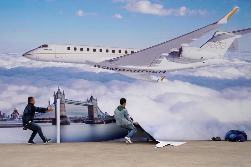 FILE PHOTO: Workers put up a billboard poster of the Bombardier Global 7000 aircraft at the Asian Business Aviation Conference and Exhibition (ABACE) at Hongqiao International Airport in Shanghai, China April 16, 2018. REUTERS/Aly Song/File Photo