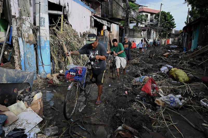 Residents of Noveleta, in Cavite province, Philippines, work their way through the ruins of a neighbourhood after Tropical Storm Nalgae hit. AFP