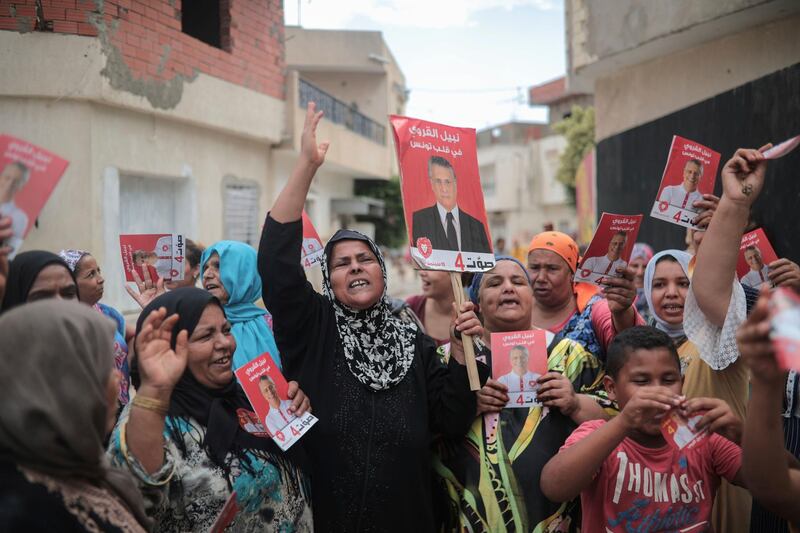 Supporters of jailed media magnate Nabil Karoui chant for his freedom and carry posters which were provided to them by his campaign officials, in Nabeul, west of Tunis, Tunisia.  AP Photo