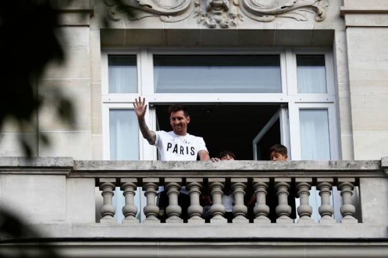Argentina football player Lionel Messi waves at fans from a balcony of the Royal Monceau hotel in Paris.