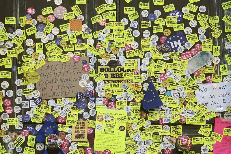 Police officers stand in front of stickers and placards left at the Cabinet Office during a march calling for a People's Vote on the final Brexit deal, in central London on October 20, 2018. Britons dreading life outside Europe gathered from all corners of the UK to London on Saturday to try to stop their country's looming breakup with the EU.
 / AFP / Niklas HALLE'N
