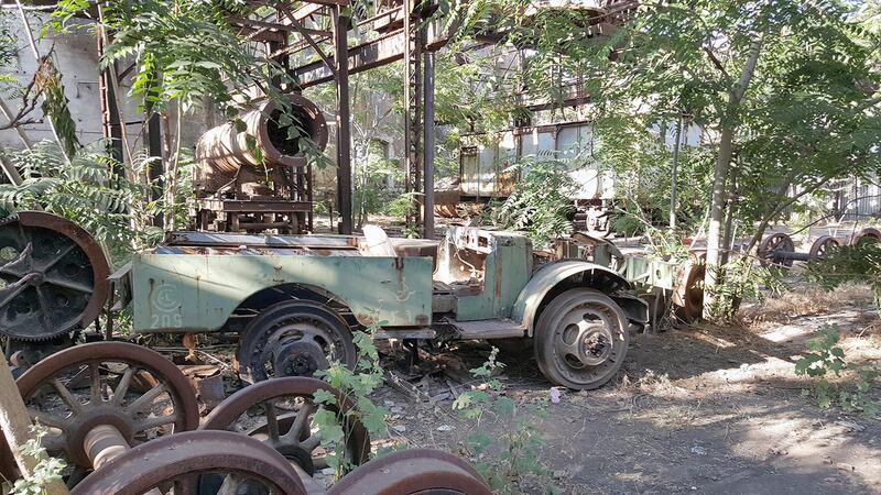 A rail maintenance car lies in front of a half-built engine in the factory building. Photo by Charles Kassatly