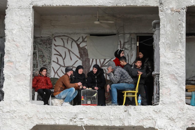 A family in Aleppo, north-west Syria, sit in a building damaged by the 7.8-magnitude earthquake. AFP