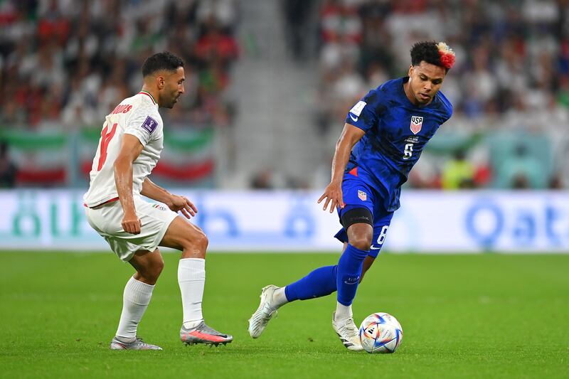 Weston McKennie of United States is challenged by Saman Ghoddos of Iran. Getty