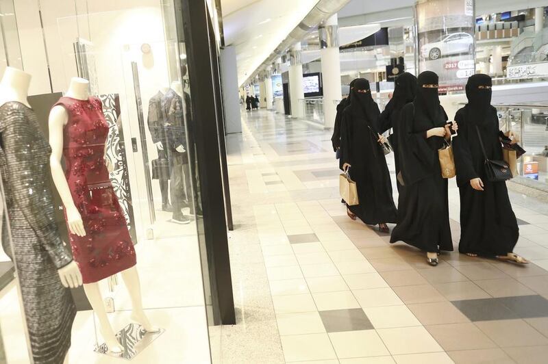 Saudi shoppers walk past clothing stores in the Kingdom Centre shopping mall in Riyadh. BMI Research forecasts an improved outlook for the kingdom's consumer sector as accelerating economic growth and government stimulus boost consumption. Bloomberg