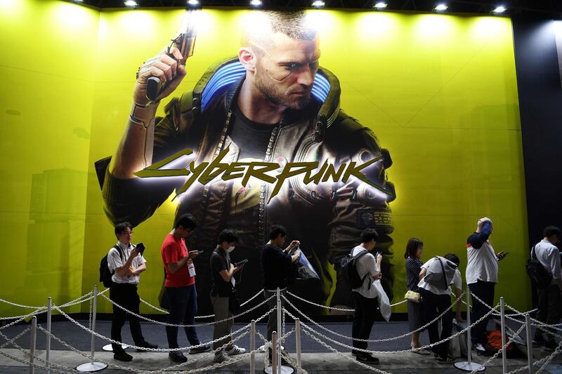 (FILES) In this file photo taken on September 12, 2019 People queue in front of a promotional banner for the video game "Cyberpunk 2077" during the Tokyo Game Show in Makuhari, Chiba Prefecture. Sony said on December 18, 2020 it was pulling the much-hyped Cyberpunk 2077 from PlayStation stores around the world, citing "customer satisfaction", after complaints of bugs, compatibility issues and even health risks. / AFP / CHARLY TRIBALLEAU
