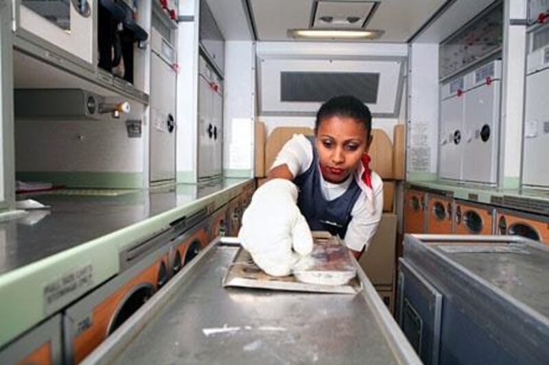 LONDON, UNITED KINGDOM - OCTOBER 26:  Muna Mamo, a cabin crew member, preparing hot food from the galley area in the economy class on board Etihad’s flight EY18 departing from London, England, to Abu Dhabi, UAE, on October 26, 2009.  (Randi Sokoloff / The National)  For Travel story *** Local Caption ***  RS002-102609-ETIHAD-GALLEY.jpg