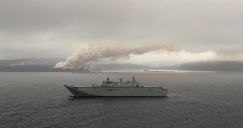 HMAS Adelaide operates off the coast of Eden, Australia, as fires burn during Operation Bushfire Assist.  Reuters