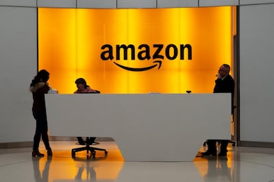 FILE - In this Feb. 14, 2019 file photo, people stand in the lobby for Amazon offices in New York.  Amazon is jumping into the podcast-making business. The online shopping giant said it plans to buy Wondery, a 4-year-old producer of popular true crime podcasts such as â€œDr. Deathâ€ and â€œDirty John.â€   (AP Photo/Mark Lennihan, File)