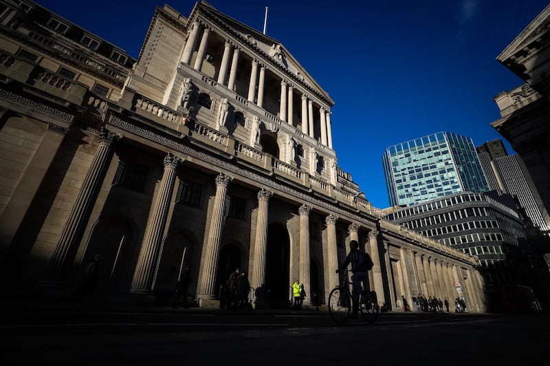 A cyclists passes the Bank of England (BOE) in the City of London, U.K., on Thursday, Feb. 7, 2019. The BOE warned that damage to the economy from Brexit has increased as it cut its growth forecast and predicted a dramatic slump in investment. Photographer: Simon Dawson/Bloomberg
