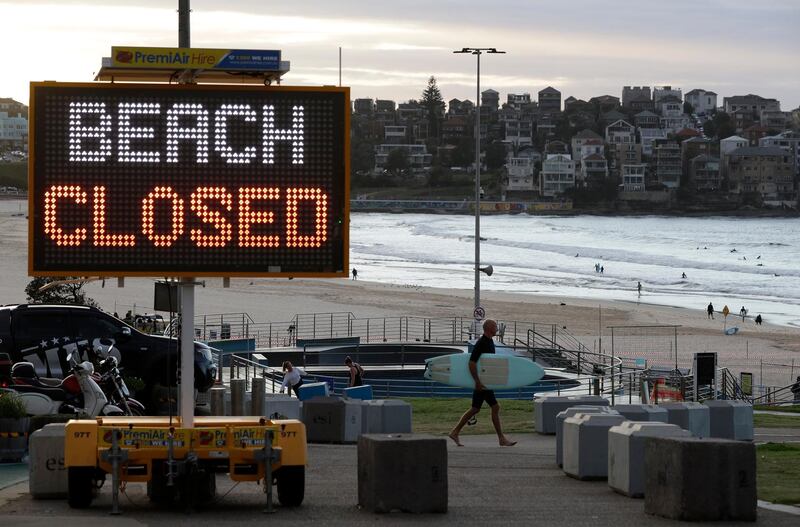 A sign indicates that Bondi Beach is closed as a surfer arrives for the 7am opening in Sydney on April 28, 2020.  AP Photo