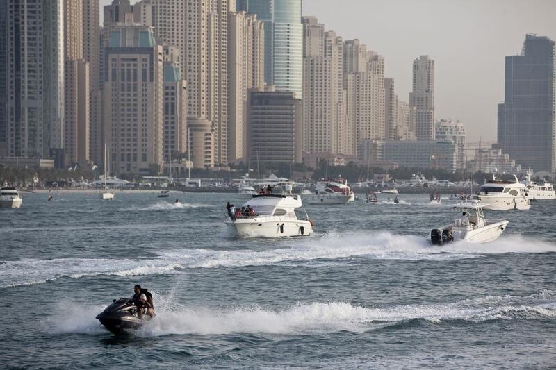 A jet ski drives past boats near the trunk of The Palm Jumeirah. Craft must be properly registered.