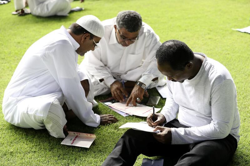 Dubai, United Arab Emirates - October 24, 2019: People mark their race card before the Emirates Holidays race on the opening meeting of the new season. Thursday the 24th of October 2019. Meydan Racecourse, Dubai. Chris Whiteoak / The National