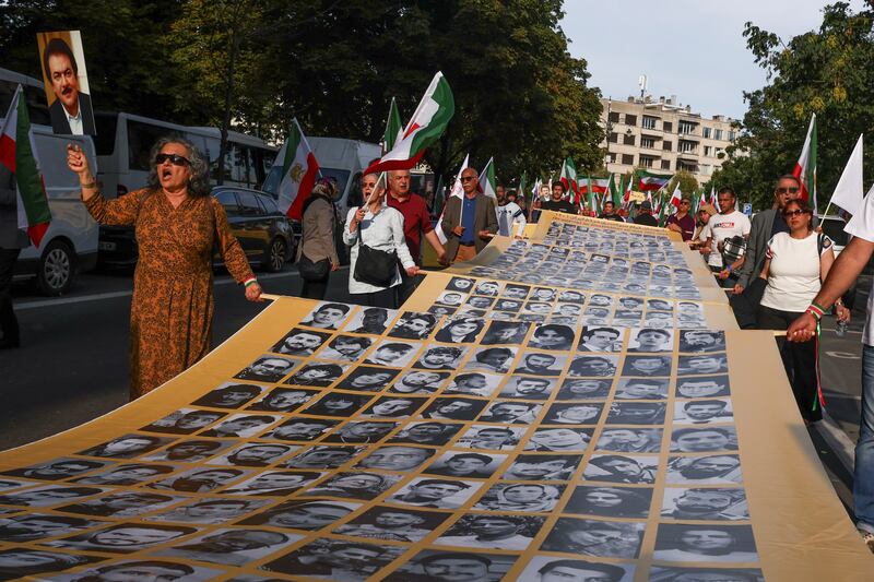 People hold a placard with pictures of, as Iranian call them, martyrs, during a rally of Iranian diaspora in Europe, on the eve of the first anniversary of the death of Mahsa Amini, which prompted protests across their country, in Brussels, Belgium. Reuters