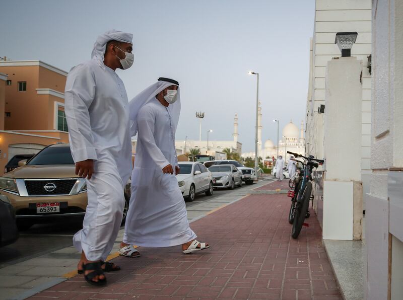 Sheikh Zayed Grand Mosque towers over the neighbourhood in Abu Dhabi as worshippers arrive at Ibn Taymiyyah Mosque for evening prayers on the day President Sheikh Khalifa died. Victor Besa / The National.