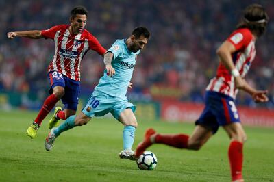 Barcelona's Lionel Messi , centre, sidesteps Atletico Madrid's Nicolas Gaitan during a Spanish La Liga soccer match between Atletico Madrid and Barcelona at the Metropolitano stadium in Madrid, Saturday, Oct. 14, 2017. The match ended in a 1-1 draw. (AP Photo/Francisco Seco)
