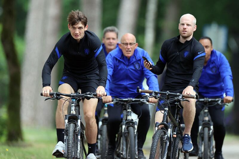 Marten de Roon (L) and Davy Klaassen ride bikes following a training session in Zeist ahead of the Euro 2020 Group C football match against North Macedonia. AFP