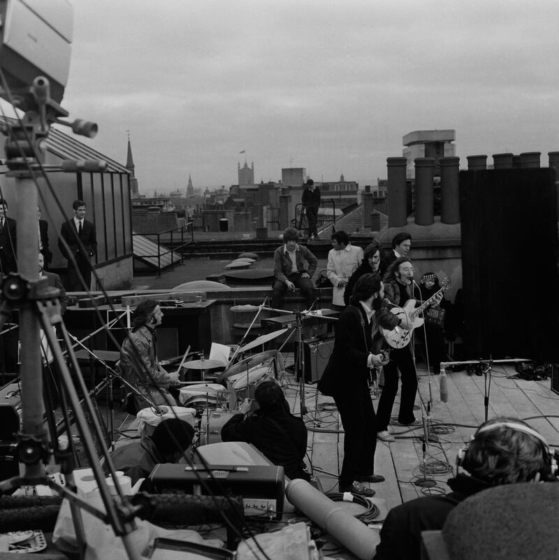 British rock group the Beatles performing their last live public concert on the rooftop of the Apple Organization building for director Michael Lindsey-Hogg's film documentary, 'Let It Be,' on Savile Row, London, UK, 30th January 1969; drummer Ringo Starr sits behind his kit, singer-songwriters Paul McCartney and John Lennon (1940 - 1980) perform at their microphones, and guitarist George Harrison (1943 - 2001) stands behind them. Lennon's wife Yoko Ono sits at right. (Photo by Evening Standard/Hulton Archive/Getty Images)