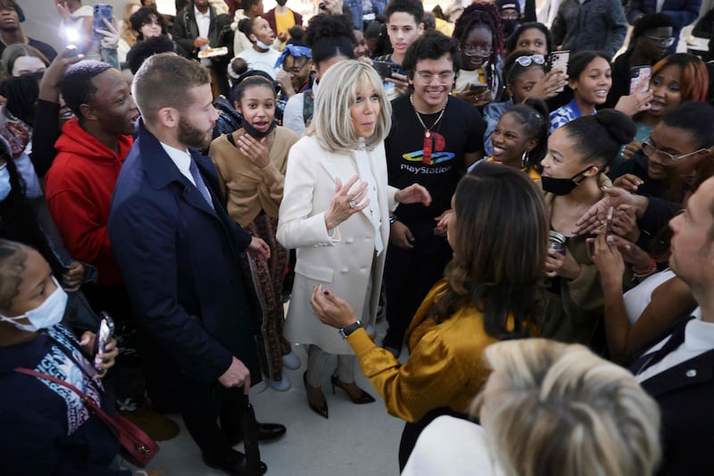 Ms Macron takes time to speak with pupils during the visit. AFP