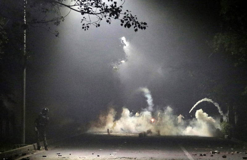 A security officer stands near tear gas fired during clashes with supporters of Mr Khan in Lahore. EPA