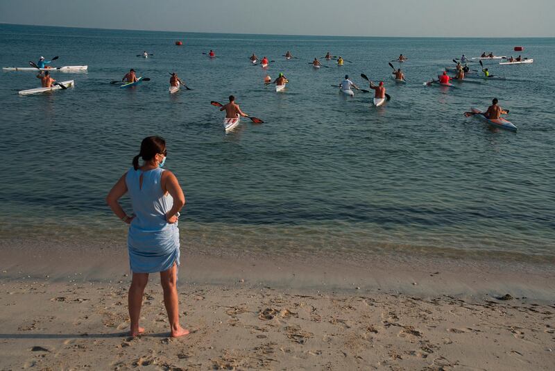A woman watches kayak racers take off from the coast of Dubai. AP Photo