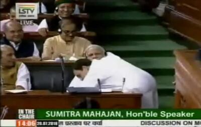 This grab made from video provided by Lok Sabha Television, a government-owned parliament channel, shows Congress party President Rahul Gandhi hugging Indian Prime Minister Narendra Modi, seated, during parliament proceedings in New Delhi, India, Friday, July 20, 2018. Gandhi accused the government of failing to live up to its promises as the Indian Parliament on Friday debated a no-confidence motion moved by the opposition against Modi's government. (Lok Sabha Television via AP)