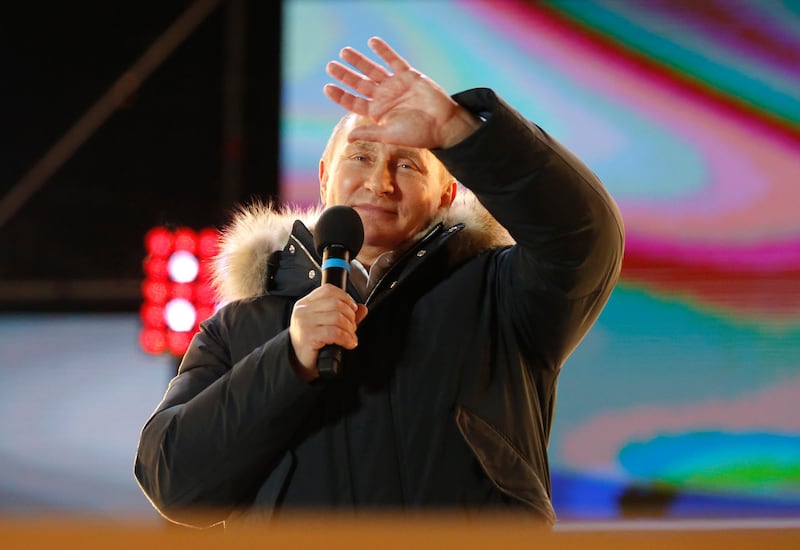 Russian President Vladimir Putin waves after speaking to supporters during a rally near the Kremlin in Moscow, Sunday, March 18, 2018. An exit poll suggests that Vladimir Putin has handily won a fourth term as Russia's president, adding six more years in the Kremlin for the man who has led the world's largest country for all of the 21st century. (AP Photo/Alexander Zemlianichenko)