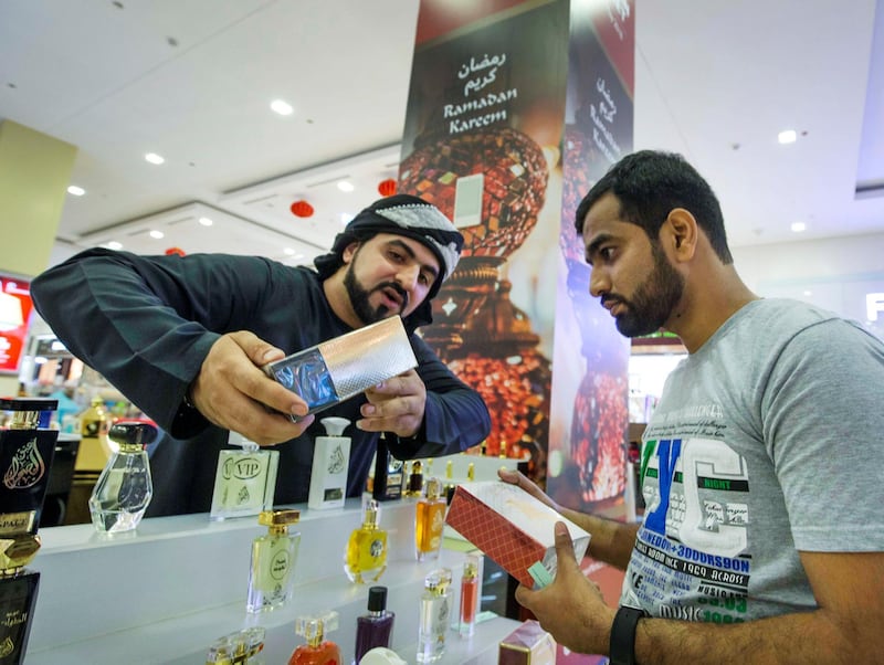 DUBAI, UNITED ARAB EMIRATES, 04 May 2018 - A salesman showing his perfume products to a shopper at Ramadan Market that opens May 3 till 19 at  Dragon Mart 2.  Leslie Pableo for The National for Ellen Fortini's story