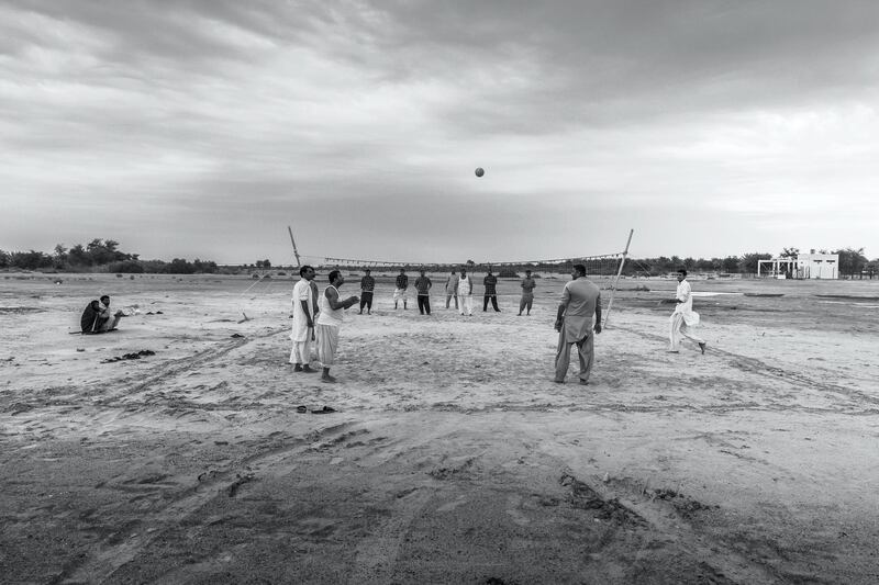 ABU DHABI, UNITED ARAB EMIRATES. 10 JANUARY 2020. Farm workers and laborers from Pakistan and India play an informal game of volleyball on a desolate patch of sand next to the Sheikh Mohammed Bin Rashid highway halfway between the Dubai and Abu Dhabi highway. (Photo: Antonie Robertson/The National) Journalist: STANDALONE. Section: Weekend.

