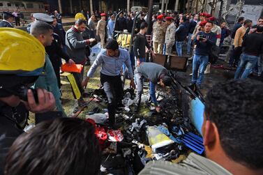 Members of the security forces and onlookers gather at the scene of a fiery train crash at the Egyptian capital Cairo's main railway station on February 27, 2019. The crash killed at least 20 people, Egyptian security and medical sources said. The accident, which sparked a major blaze at the Ramses station, also injured 40 others, the sources said. / AFP / Ahmad Hassan