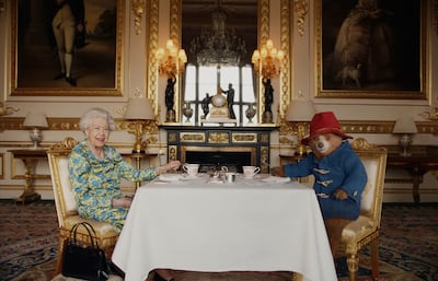 Queen Elizabeth II and Paddington Bear having cream tea at Buckingham Palace taken from a film that was shown at the BBC Platinum Party at the Palace.