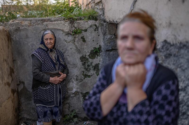 TOPSHOT - Women stand by the entrance to a basement during shelling in the city of Terter, Azerbaijan, on October 13, 2020, during the ongoing military conflict between Armenia and Azerbaijan over the breakaway region of Nagorno-Karabakh. / AFP / Bulent Kilic
