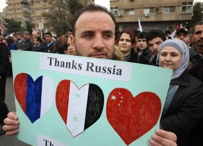 A Syrian pro-government supporter holds upa sign as a convoy carrying Russian Foreign Minister Sergei Lavrov heads towards the presidential palace in Damascus on February 7, 2012.  Moscow's top diplomat was holding talks with Syrian President Bashar al-Assad after being cheered on his arrival in Damascus by thousands of regime supporters who took to the streets to "thank" Russia, according to state media, for vetoing along with China a UN Security Council resolution condemning the Assad regime's crackdown on protesters.
AFP PHOTO/LOUAI BESHARA
 *** Local Caption ***  814916-01-08.jpg